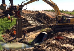 Chantier de l’autoroute 25 – 7 juin 2017 Les travailleurs mettent en place le batardeau d’une dizaine de mètres de haut qui servira à dévier l’eau pendant l’installation du nouveau ponceau. travaux